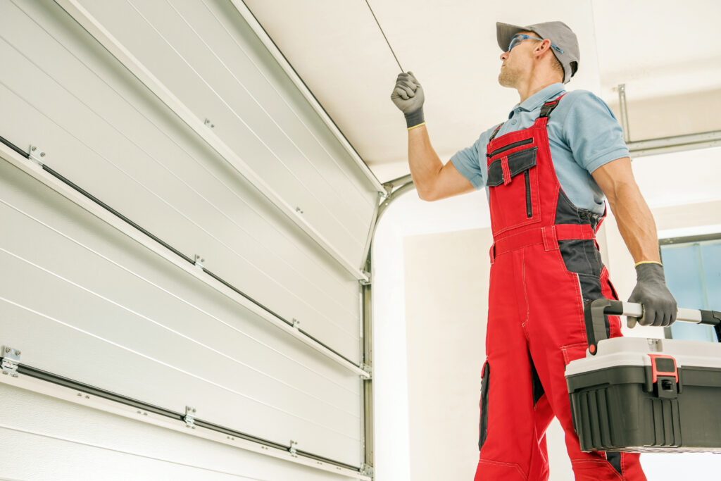 Expert garage door repair technician inspecting door and holding tools in Albany, NY.