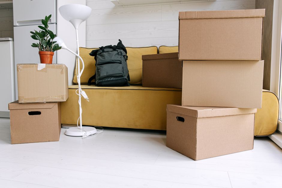 Moving boxes and a set of house keys on a wooden floor